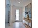Elegant entryway with neutral tile flooring, decorative console table, and stylish artwork creates a welcoming ambiance for guests at 2208 Darley Oak Way, North Port, FL 34289