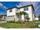 Charming two-story home featuring a gray two-car garage, landscaped yard, and a covered front entryway at 2208 Darley Oak Way, North Port, FL 34289