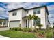 Charming two-story home featuring a manicured lawn, two palm trees, and an attached two car garage at 2208 Darley Oak Way, North Port, FL 34289