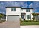 Charming two-story home featuring a gray two-car garage, landscaped yard, and a covered front entryway at 2208 Darley Oak Way, North Port, FL 34289