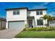 Charming two-story home featuring a gray two-car garage, landscaped yard, and a covered front entryway at 2208 Darley Oak Way, North Port, FL 34289