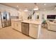 Bright kitchen features stainless steel appliances, white cabinets, and a large center island with sink at 2208 Darley Oak Way, North Port, FL 34289