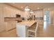 Bright, modern kitchen featuring white cabinets, an island with seating, and stainless steel appliances for a functional cooking space at 2208 Darley Oak Way, North Port, FL 34289