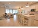 Open concept kitchen with white cabinets, an island with seating, and seamless flow to the living and dining areas at 2208 Darley Oak Way, North Port, FL 34289