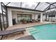 Screened-in patio with ceiling fans and comfortable seating area with views of the sparkling pool at 2208 Darley Oak Way, North Port, FL 34289