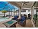 Screened patio with ceiling fan, outdoor seating, BBQ, pool and view into home at 2208 Darley Oak Way, North Port, FL 34289