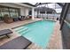 Relax by the sparkling pool featuring a screened enclosure, surrounded by lush landscaping and comfortable lounge chairs at 2208 Darley Oak Way, North Port, FL 34289