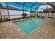 Sparkling pool featuring a screened-in lanai, white vinyl fence, and mature tropical landscaping at 2208 Darley Oak Way, North Port, FL 34289