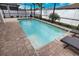 Sparkling pool with brick pavers, beach balls, and relaxing lounge chairs in screened in lanai area at 2208 Darley Oak Way, North Port, FL 34289