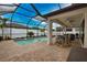 Screened-in pool area with an inground pool, a bar with seating, and patio furniture at 2208 Darley Oak Way, North Port, FL 34289