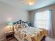 Cozy bedroom featuring a queen sized bed, a window with blinds and decorative lamps at 2444 Daisy Dr, North Port, FL 34289