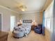 Comfortable bedroom with neutral carpet, ceiling fan, accent chair, and bright window light at 2444 Daisy Dr, North Port, FL 34289