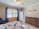 Bright bedroom featuring a large window, wooden dresser, and access to hallway at 2444 Daisy Dr, North Port, FL 34289