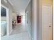 Bright hallway with tile flooring and neutral paint, leading to the dining and living area at 2444 Daisy Dr, North Port, FL 34289
