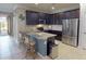 A kitchen features stainless steel appliances, an island with seating, and dark cabinets at 2444 Daisy Dr, North Port, FL 34289