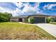 Charming single-story home featuring a well-manicured lawn, attached two-car garage and beautifully landscaped front yard at 626 Lomond Dr, Port Charlotte, FL 33953