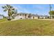 Beautiful single-story home boasting a well-manicured lawn, palm trees, and a two-car garage at 73 Santarem Cir, Punta Gorda, FL 33983