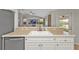 Bright kitchen with stainless steel dishwasher and sink overlooking the living room creating an open floorplan at 73 Santarem Cir, Punta Gorda, FL 33983