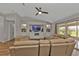 Cozy living room with built-in shelving, a ceiling fan, and sliding glass doors at 73 Santarem Cir, Punta Gorda, FL 33983