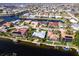Aerial shot of a waterfront home with a pool, dock, and lush landscaping in a residential neighborhood at 936 Lassino Ct, Punta Gorda, FL 33950