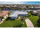 Stunning waterfront home with a metal roof, lush landscaping, and a private dock on a sunny day at 936 Lassino Ct, Punta Gorda, FL 33950