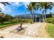 Manicured backyard featuring a mermaid statue and paver path leading to the screened-in lanai and lush landscaping at 936 Lassino Ct, Punta Gorda, FL 33950