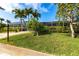 Well-manicured lawn and landscaping complemented by a white screened enclosure surrounding the pool area at 936 Lassino Ct, Punta Gorda, FL 33950