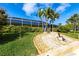 Landscaped backyard featuring a screened pool enclosure, lush plantings, and a decorative statue at 936 Lassino Ct, Punta Gorda, FL 33950