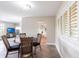 This dining area features a round wood table, four chairs, and natural light from shuttered windows at 936 Lassino Ct, Punta Gorda, FL 33950