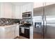 Kitchen featuring stainless appliances, modern backsplash, and white cabinets at 936 Lassino Ct, Punta Gorda, FL 33950