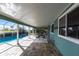 Covered patio with screened enclosure leading to the pool and lush landscaping at 936 Lassino Ct, Punta Gorda, FL 33950
