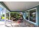 Charming screened patio featuring wicker chairs, colorful rug, and view of the lush backyard at 936 Lassino Ct, Punta Gorda, FL 33950
