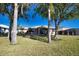 Spacious backyard with mature trees, a lawn, and an enclosed lanai area at 1675 Blue Lake Cir, Punta Gorda, FL 33983