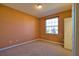 This empty bedroom is painted orange, and it has carpet, a closet, and a window at 1675 Blue Lake Cir, Punta Gorda, FL 33983