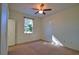 This bedroom features neutral carpet, ceiling fan, and natural light from the window at 1675 Blue Lake Cir, Punta Gorda, FL 33983