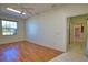 Clean bedroom with wood floors and large window letting in light. View of tiled hallway through doorway at 1675 Blue Lake Cir, Punta Gorda, FL 33983