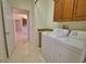 Functional laundry room featuring a utility sink, washer, dryer, and ample storage cabinets for household essentials at 1675 Blue Lake Cir, Punta Gorda, FL 33983