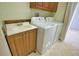 Functional laundry room featuring a utility sink, washer, dryer, and ample storage cabinets for household essentials at 1675 Blue Lake Cir, Punta Gorda, FL 33983