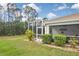 Picturesque backyard showcasing a screened lanai with a glimpse of outdoor furniture and verdant landscaping around the house at 2153 Boxwood St, North Port, FL 34289