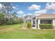Lush backyard featuring a screened lanai with outdoor furniture, complemented by well-kept lawn and manicured landscaping at 2153 Boxwood St, North Port, FL 34289