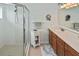 Bathroom with double sink vanity, white cabinets, and a glass door shower at 2153 Boxwood St, North Port, FL 34289