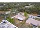 Aerial view of the property, including the house, fenced yard, and surrounding neighborhood with mature trees at 2281 Tolbert St, Port Charlotte, FL 33948