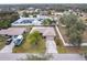 Aerial view of house featuring well-maintained lawn, mature trees, driveway, and surrounding neighborhood at 2281 Tolbert St, Port Charlotte, FL 33948