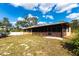 View of the house, including the screened-in back porch, with a spacious backyard that is partially landscaped at 2281 Tolbert St, Port Charlotte, FL 33948