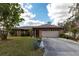 Charming single-story home featuring a two-car garage, well-maintained lawn, and mature landscaping at 2281 Tolbert St, Port Charlotte, FL 33948