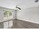 Well-lit bedroom with a large window, ceiling fan, and wood-look flooring, providing a comfortable living space at 23227 Adela Ave, Port Charlotte, FL 33952