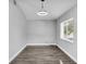 Bright bedroom featuring wood-look floors, a modern light fixture, and natural light from a large window at 23227 Adela Ave, Port Charlotte, FL 33952