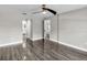 A bedroom with wood-look floors offering views into an en-suite bathroom and toward the kitchen area at 23227 Adela Ave, Port Charlotte, FL 33952