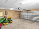 Spacious two-car garage featuring epoxy flooring and ample storage for vehicles and lawn equipment at 23227 Adela Ave, Port Charlotte, FL 33952
