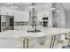 Bright kitchen featuring a large island with seating, modern appliances, white cabinets, and stylish pendant lighting at 23227 Adela Ave, Port Charlotte, FL 33952